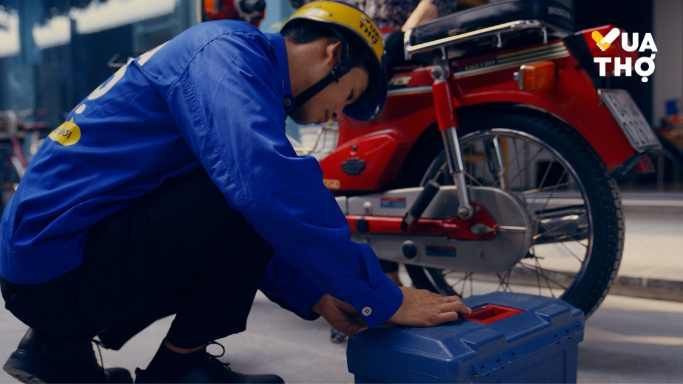 thợ mặc áo xanh đóng hộp sửa xe